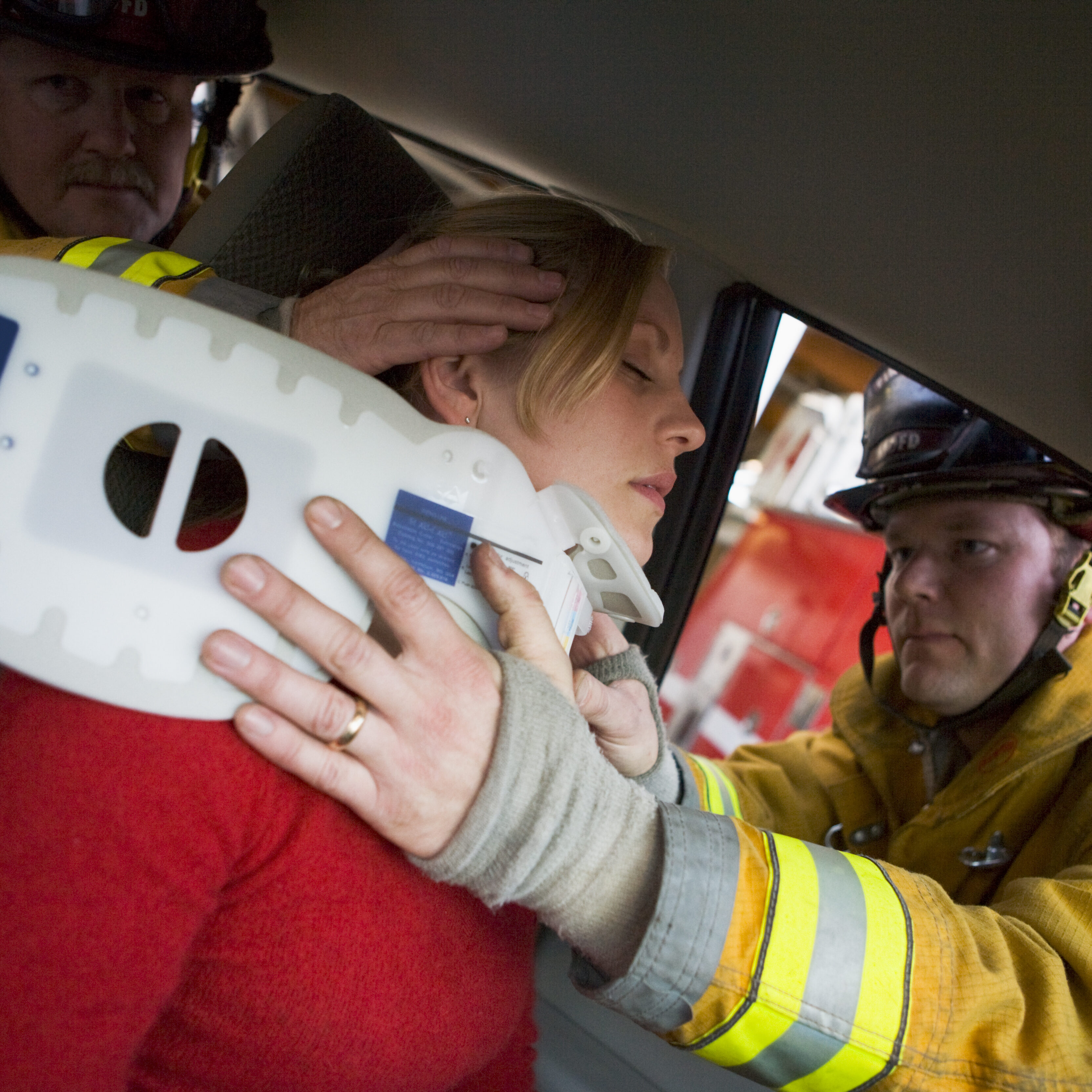 Firefighters helping an injured woman in a car