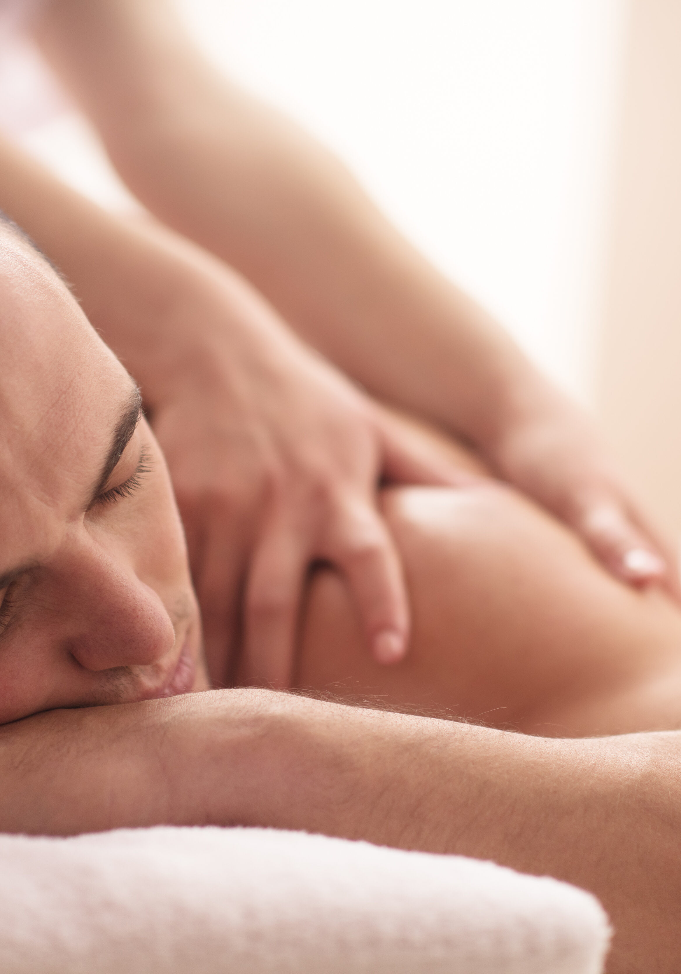 Positive young man having a back massage in a spa center